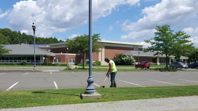 Man weed whacking at elementary school.